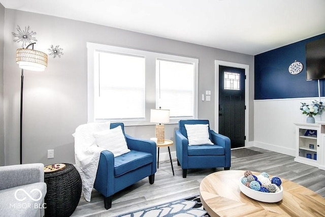 living room with wainscoting and wood finished floors