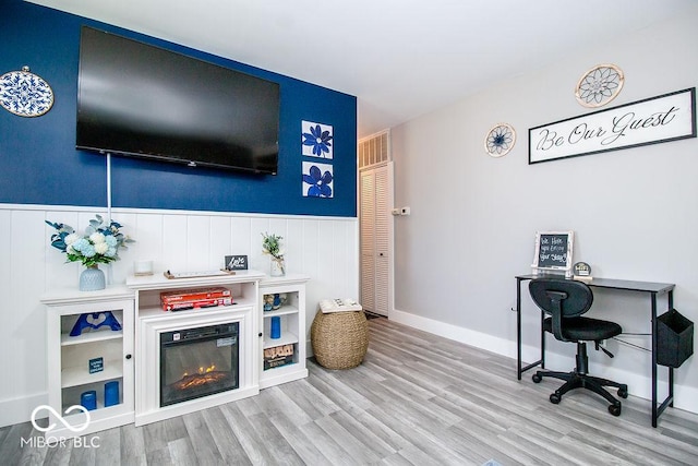 home office with wainscoting and wood finished floors