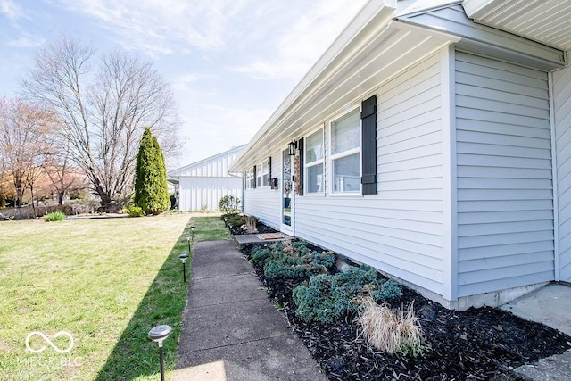 view of side of home with a yard