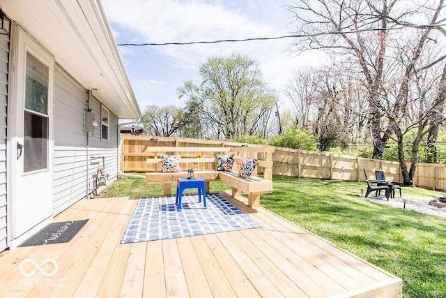 wooden terrace with a lawn and a fenced backyard