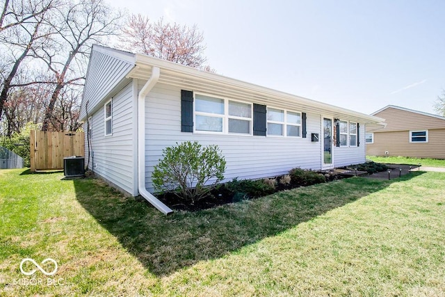 view of front of property featuring fence, central AC, and a front lawn