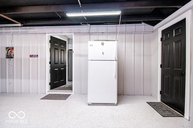 below grade area with freestanding refrigerator and a garage