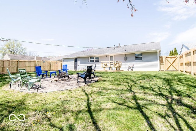 back of property featuring a lawn, a fenced backyard, a fire pit, and a patio