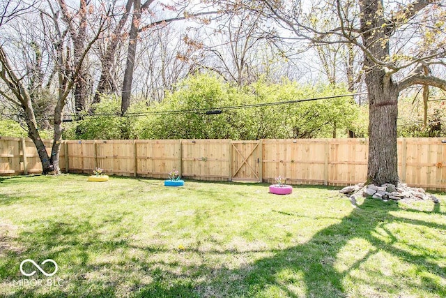 view of yard featuring a fenced backyard and a gate