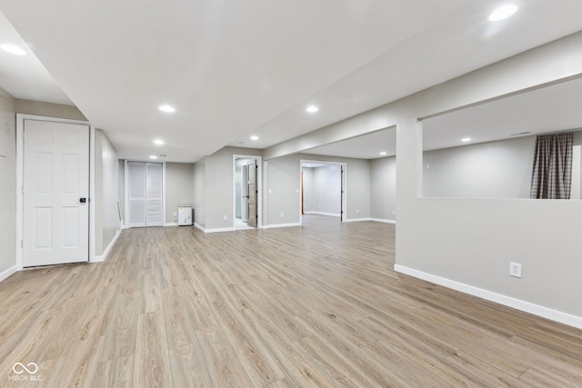 finished basement featuring recessed lighting, baseboards, and light wood-style floors