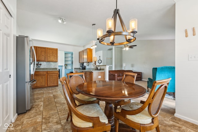 dining space with baseboards, ceiling fan with notable chandelier, and stone finish floor