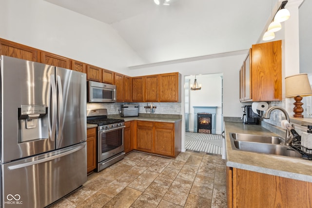kitchen with brown cabinetry, a sink, appliances with stainless steel finishes, and tasteful backsplash
