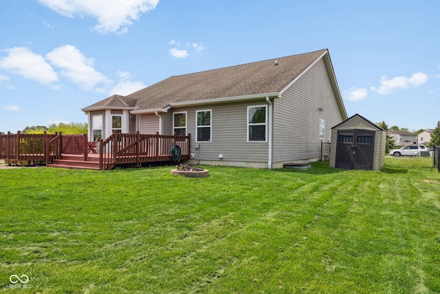 rear view of house with a yard, a deck, an outbuilding, and a storage unit