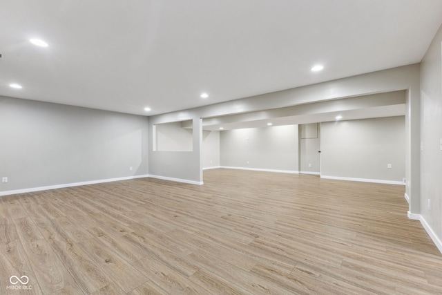 finished basement featuring recessed lighting, light wood-style flooring, and baseboards