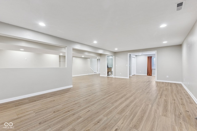 finished below grade area featuring recessed lighting, baseboards, and light wood-type flooring