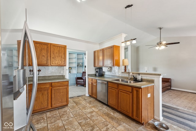 kitchen with a sink, brown cabinetry, stainless steel appliances, a peninsula, and tasteful backsplash
