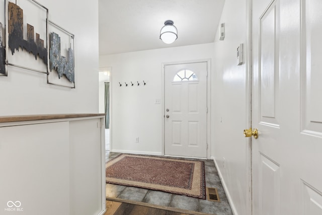 foyer entrance with baseboards and visible vents