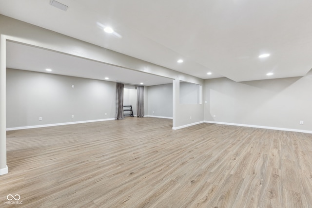finished basement featuring recessed lighting, baseboards, visible vents, and light wood-style flooring