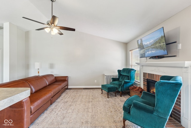 living room with baseboards, a ceiling fan, a brick fireplace, and vaulted ceiling