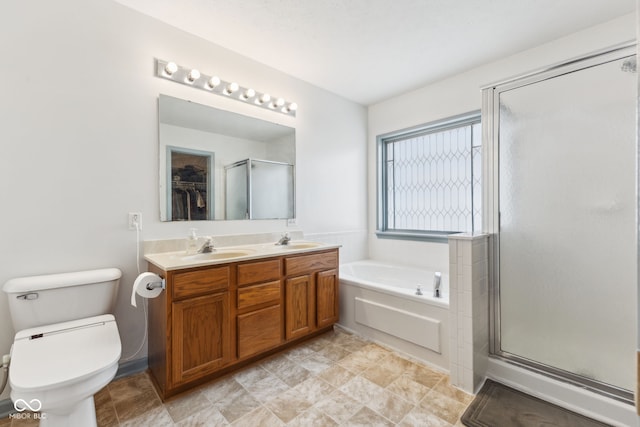 bathroom with toilet, a sink, a garden tub, and a stall shower