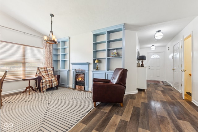 living room with baseboards, a fireplace with flush hearth, a chandelier, and hardwood / wood-style flooring