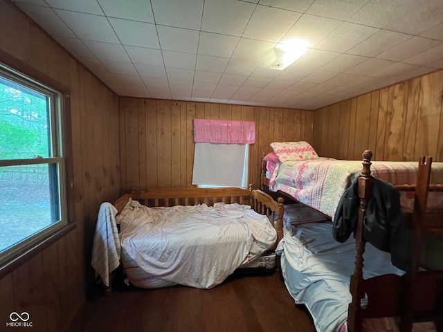 bedroom with wooden walls and wood finished floors