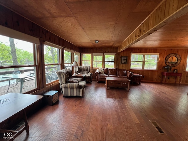living area featuring wood ceiling, wood-type flooring, wood walls, and visible vents