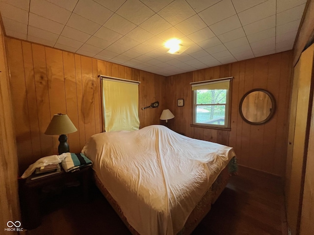 bedroom featuring wood walls and wood finished floors