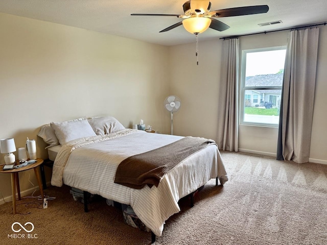 carpeted bedroom with baseboards, ceiling fan, and visible vents