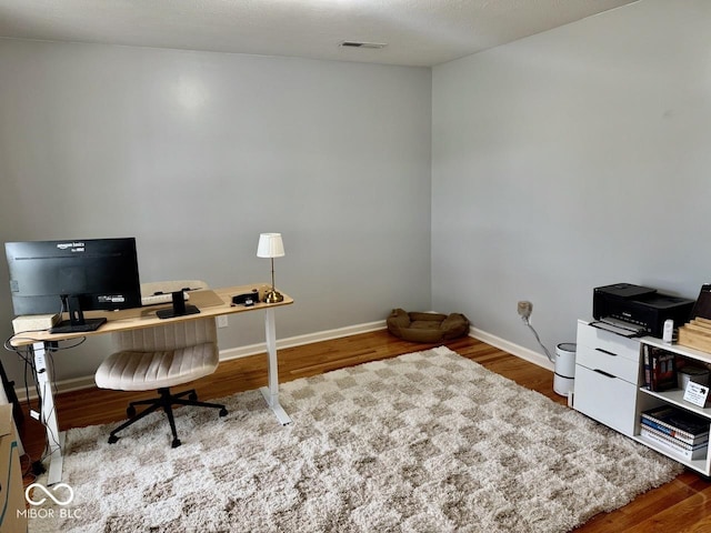 office with baseboards, wood finished floors, and visible vents