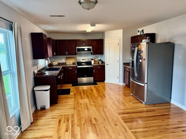 kitchen featuring a sink, appliances with stainless steel finishes, a wealth of natural light, and visible vents
