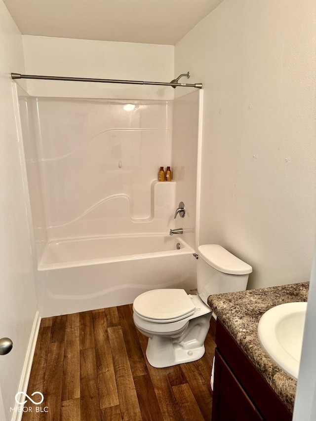 full bathroom with toilet, wood finished floors, shower / bathing tub combination, and vanity