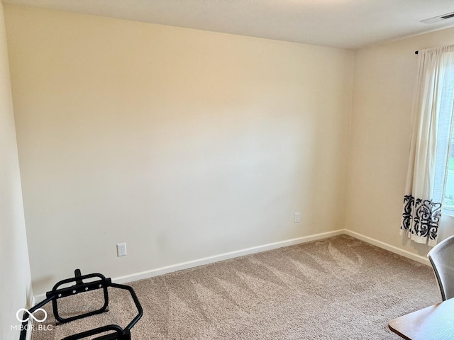 carpeted empty room with baseboards, a wealth of natural light, and visible vents