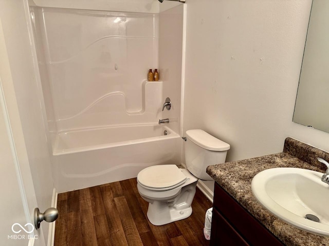 bathroom with vanity, wood finished floors, toilet, baseboards, and shower / bath combination