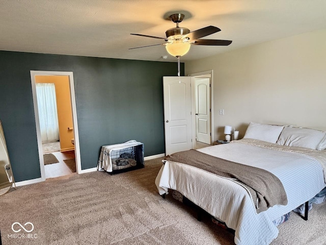 carpeted bedroom with baseboards, ceiling fan, and ensuite bath