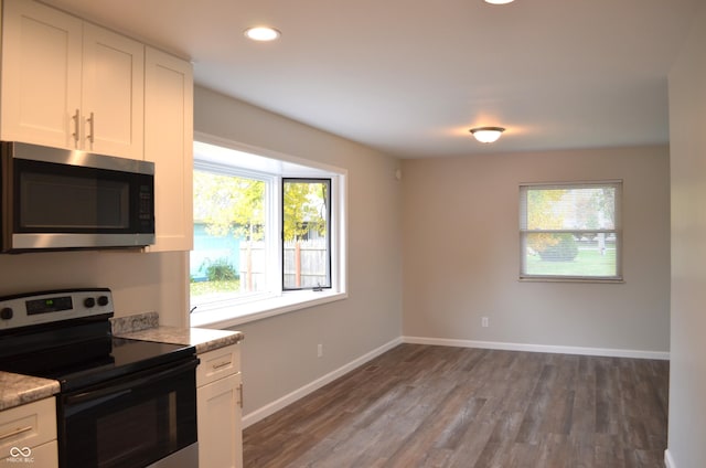 kitchen with stainless steel appliances, baseboards, recessed lighting, white cabinetry, and wood finished floors