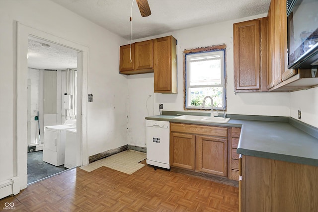 kitchen featuring brown cabinetry, washing machine and clothes dryer, white dishwasher, black microwave, and a sink