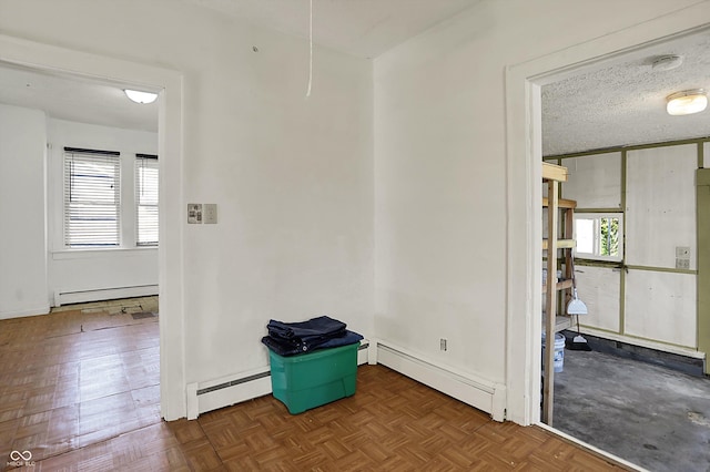 unfurnished room featuring baseboards, a textured ceiling, and baseboard heating
