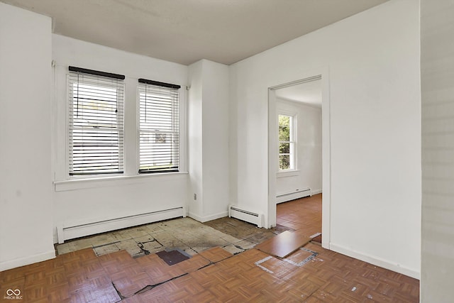 unfurnished room with baseboards and a baseboard heating unit