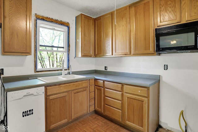 kitchen with black microwave, a textured ceiling, a sink, and dishwasher