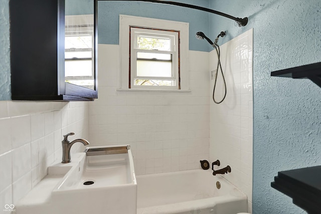 full bath featuring shower / bathtub combination and a textured wall