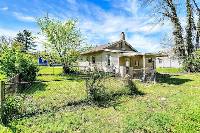 rear view of property with a lawn, fence, and a chimney
