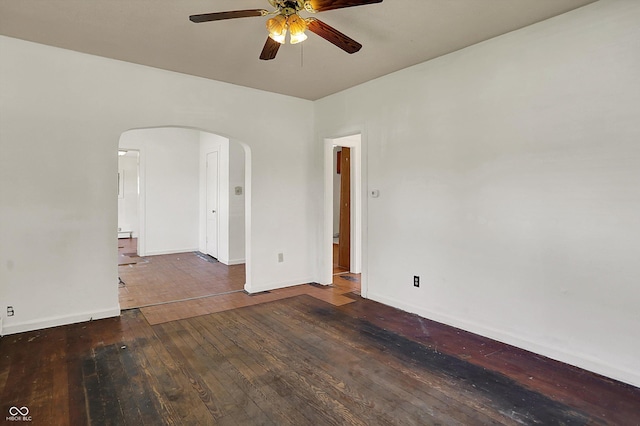 unfurnished room with baseboards, arched walkways, ceiling fan, and hardwood / wood-style floors