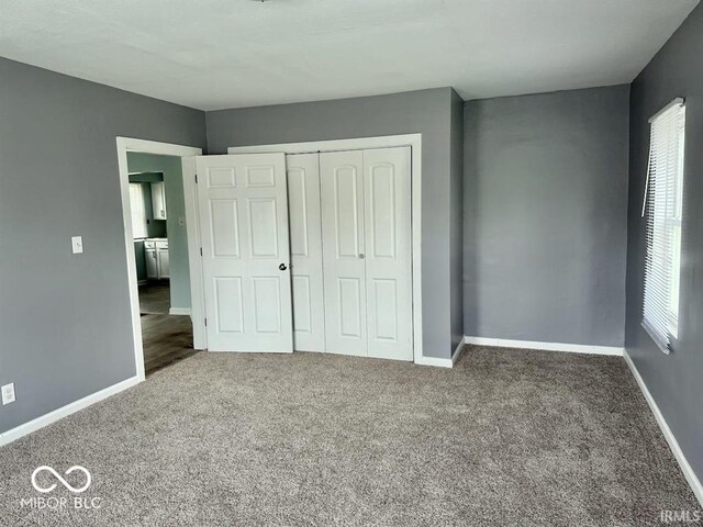 unfurnished bedroom featuring a closet, carpet flooring, and multiple windows