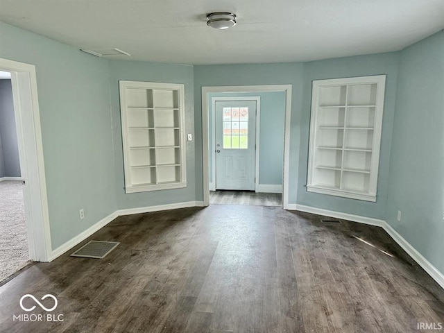 doorway featuring baseboards, visible vents, built in features, and dark wood finished floors