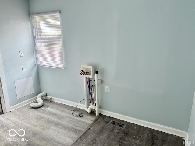 clothes washing area featuring laundry area, visible vents, wood finished floors, baseboards, and hookup for a washing machine