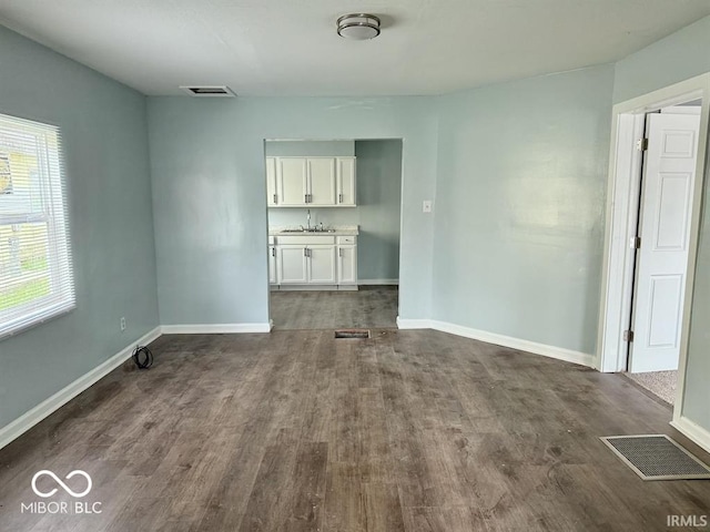 interior space featuring visible vents, a sink, and dark wood-type flooring