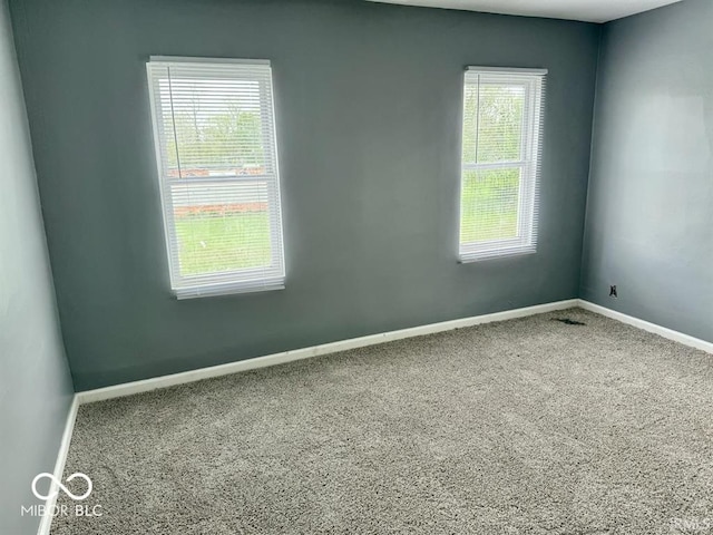 spare room with baseboards and carpet