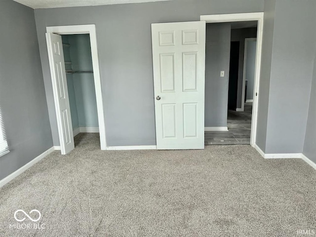 unfurnished bedroom featuring carpet flooring, baseboards, and a closet