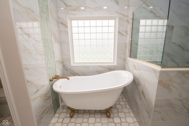 12520 E Stanley Rd, Selma, IN 47383 - bathroom featuring a healthy amount of sunlight, tile walls, and a soaking tub