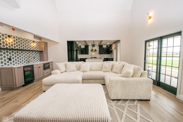 12520 E Stanley Rd, Selma, IN 47383 - living area with a towering ceiling, beverage cooler, bar area, and light wood-type flooring