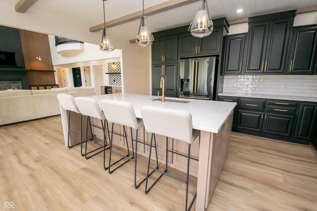 12520 E Stanley Rd, Selma, IN 47383 - kitchen featuring light wood-style floors, backsplash, a sink, beamed ceiling, and stainless steel fridge