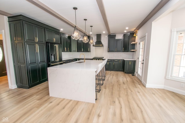 12520 E Stanley Rd, Selma, IN 47383 - kitchen featuring tasteful backsplash, wall chimney exhaust hood, a sink, refrigerator with ice dispenser, and light wood-style flooring