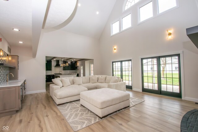12520 E Stanley Rd, Selma, IN 47383 - living room with light wood-style floors, baseboards, a notable chandelier, and high vaulted ceiling