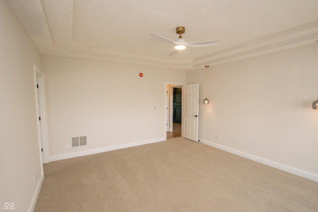 12520 E Stanley Rd, Selma, IN 47383 - spare room featuring ceiling fan, light colored carpet, visible vents, a raised ceiling, and baseboards